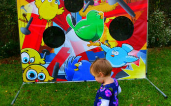 A toddler girl stomps on the bird launcher, to score big points on the Furious Fowl game.