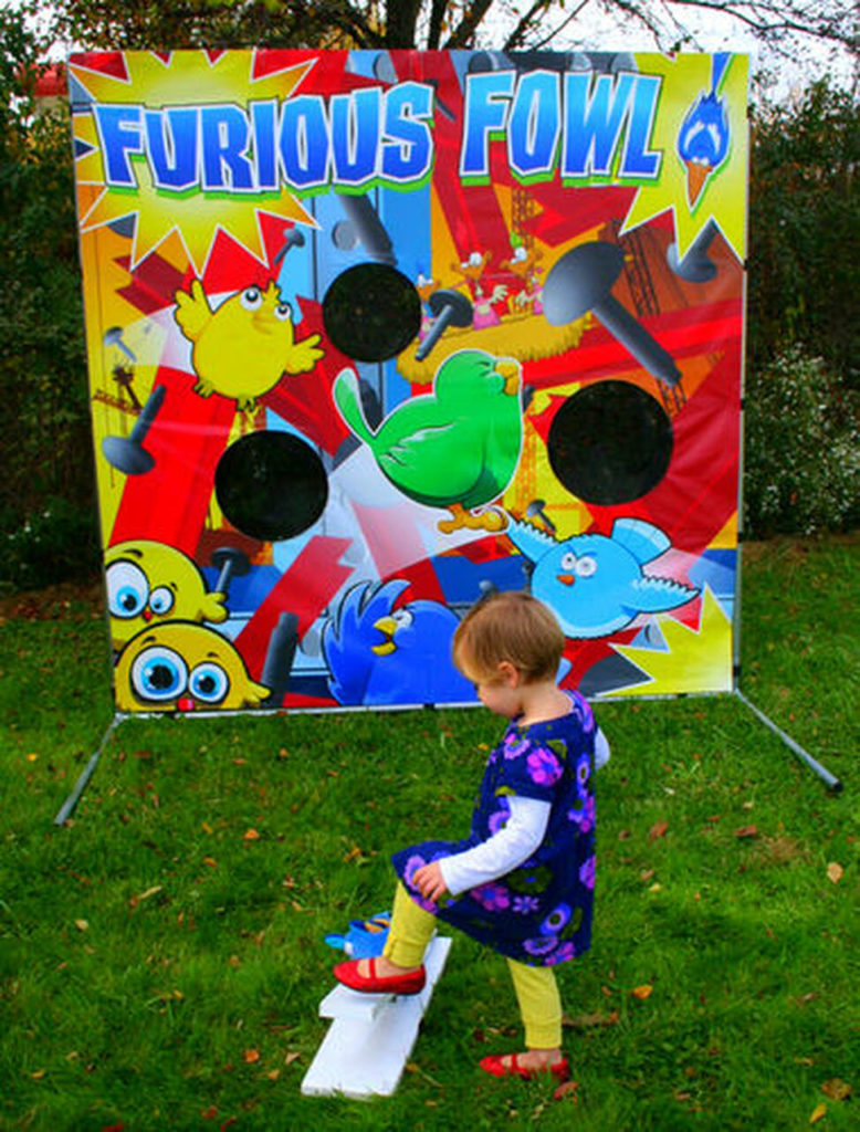 A toddler girl stomps on the bird launcher, to score big points on the Furious Fowl game.